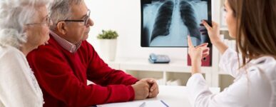 A doctor shows an older couple a lung X-ray