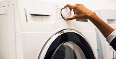 A hand moving a washing machine dial