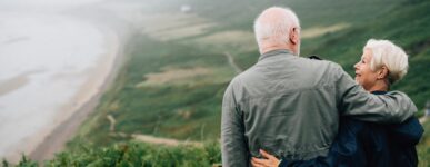 Older couple embracing each other overlooking the ocean