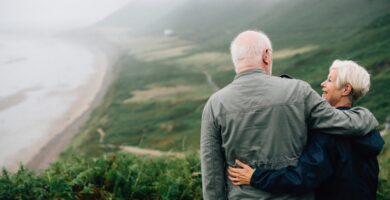 Older couple embracing each other overlooking the ocean