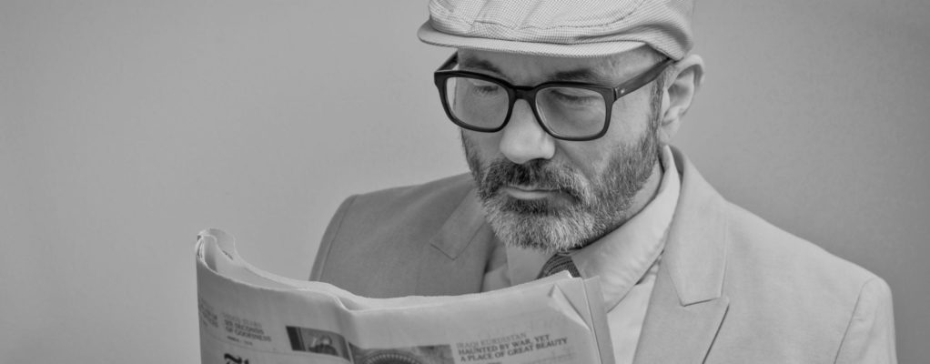 Man in glasses reading the New York Times