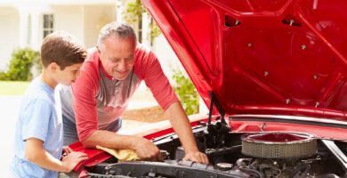 Grandfather and grandson work on a car