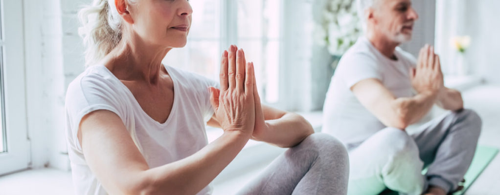 two seniors practice meditation