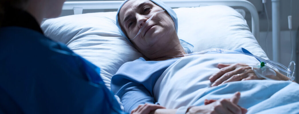a woman lies in a hospital bed while receiving cancer treatment