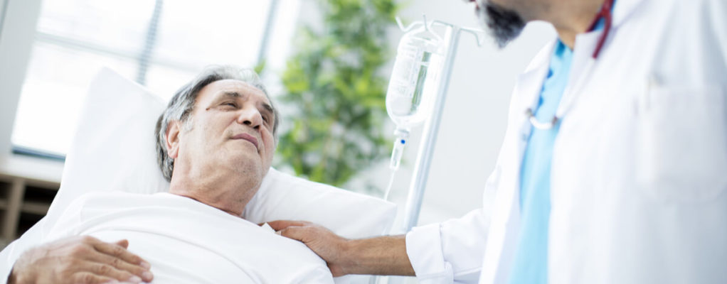 a man in a hospital bed talks to a doctor