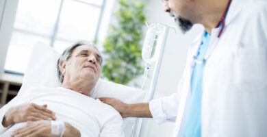 a man in a hospital bed talks to a doctor