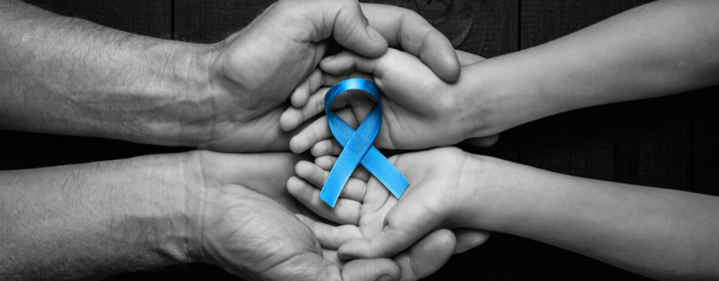 Two sets of hands holding a blue ribbon