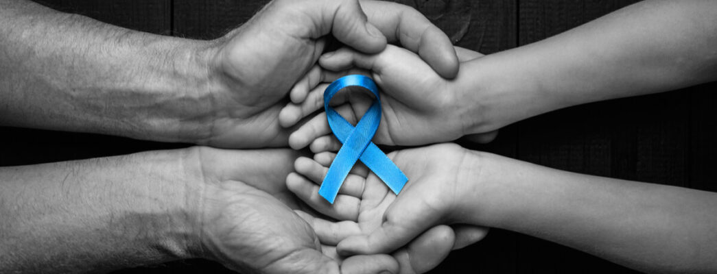 Two sets of hands holding a blue ribbon