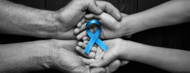 Two sets of hands holding a blue ribbon