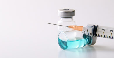 a needle resting on a bottle of fluid