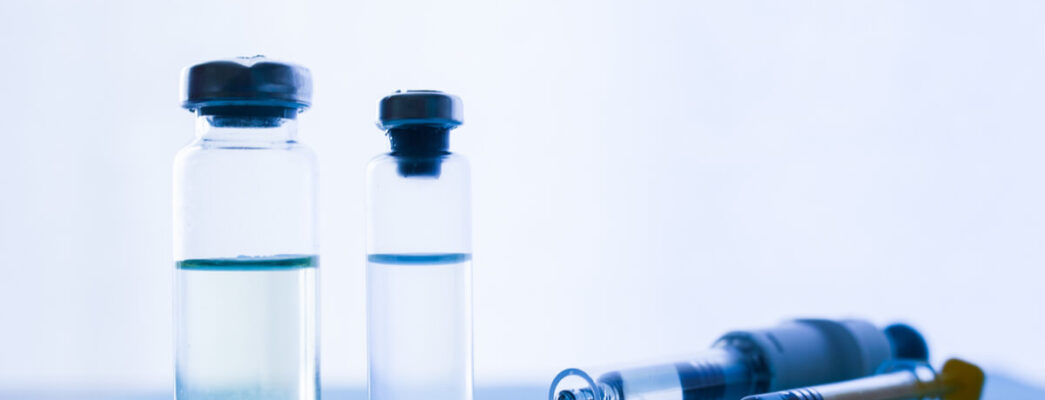 Two vials of a cancer treatment next to needles