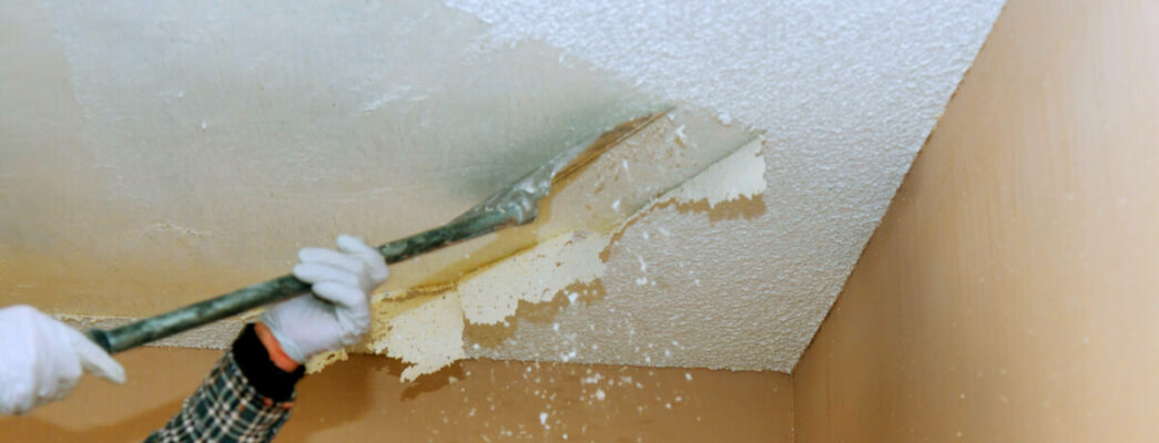 industrial worker removing popcorn ceiling with asbestos