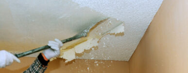 industrial worker removing popcorn ceiling with asbestos
