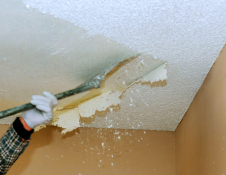 industrial worker removing popcorn ceiling with asbestos