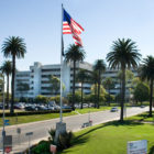 Image of the West Los Angeles VA Medical Center. The facility is very large and has several palm trees planted in front.