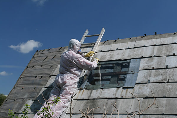 Man in hazmat suit working on a roof