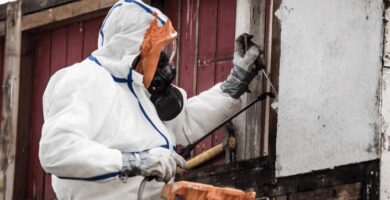 Man in hazmat suit working on home