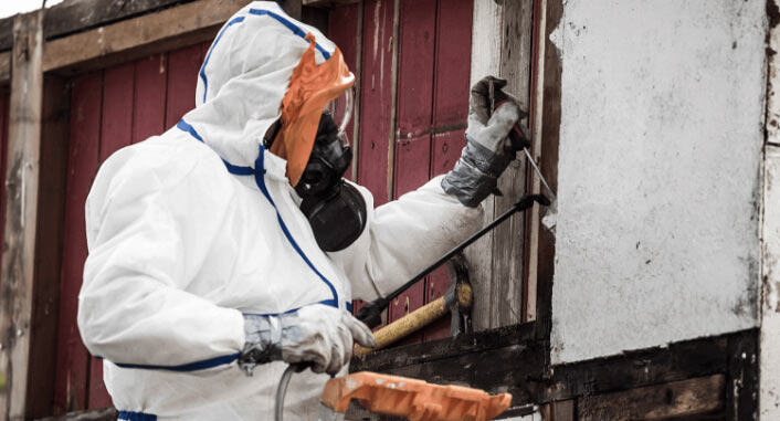 Man in hazmat suit working on home