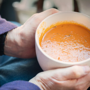 A person holds a bowl of soup