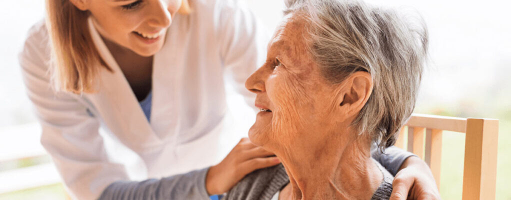 Elderly woman being comforted by nurse