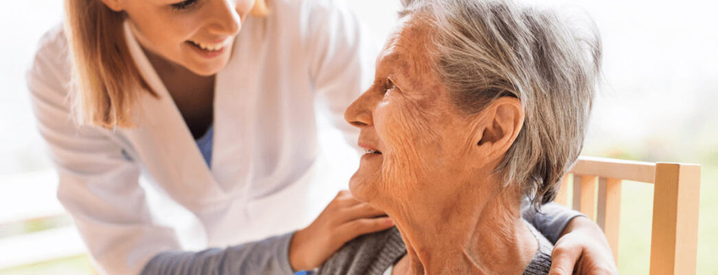 Elderly woman being comforted by nurse