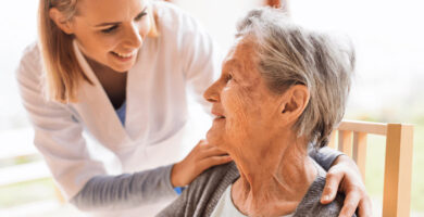 Elderly woman being comforted by nurse