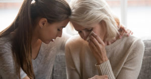 A young woman consoles an older woman