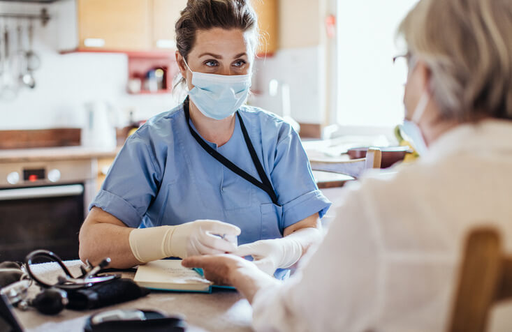 Nurse taking a blood sample from an elderly patient