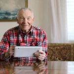 An older man uses a tablet