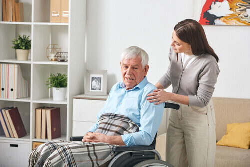 A caregiver assists a mesothelioma patient in a wheelchair