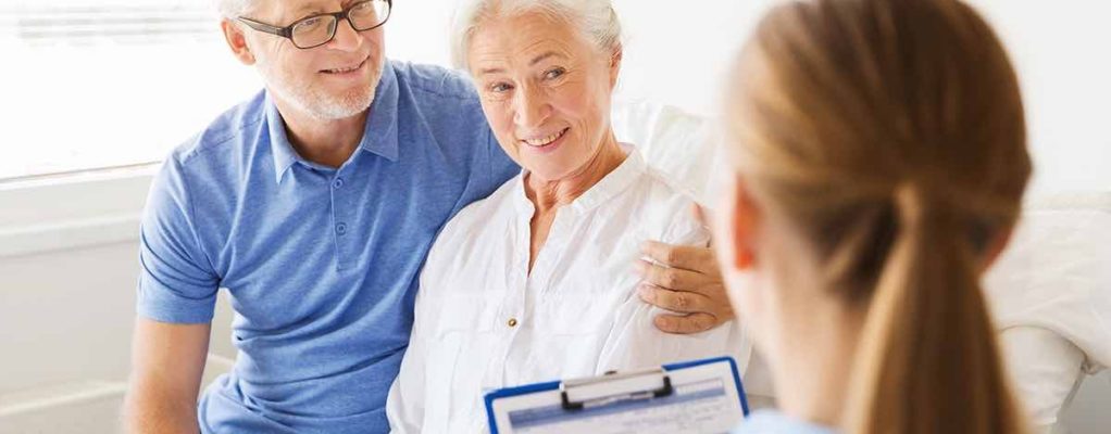 Elderly couple talking to nurse