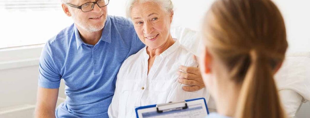 Elderly couple talking to nurse