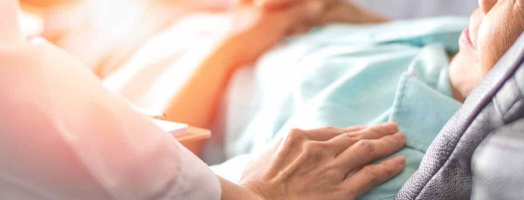 Doctor with hands on elderly patient