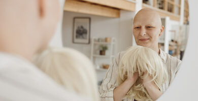 Bald woman holding wig
