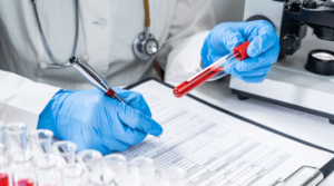 A lab tech analyzing a vial of blood