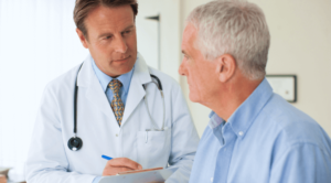 A male doctor speaks with an older male patient
