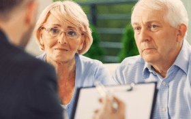 An older couple meets with a mesothelioma lawyer to explore their options for financial assistance