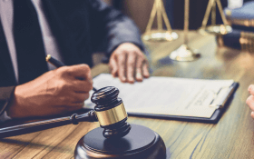 A lawyer at a mesothelioma law firm completes paperwork at his desk