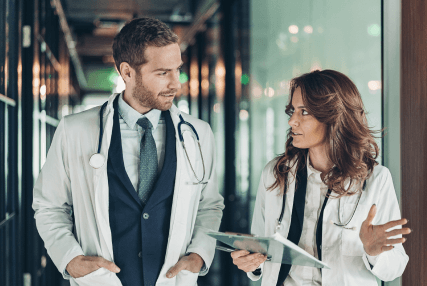 Two doctors walk down a hospital hallway