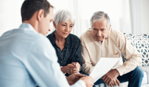 Elderly couple talking to an attorney about asbestos claims payouts