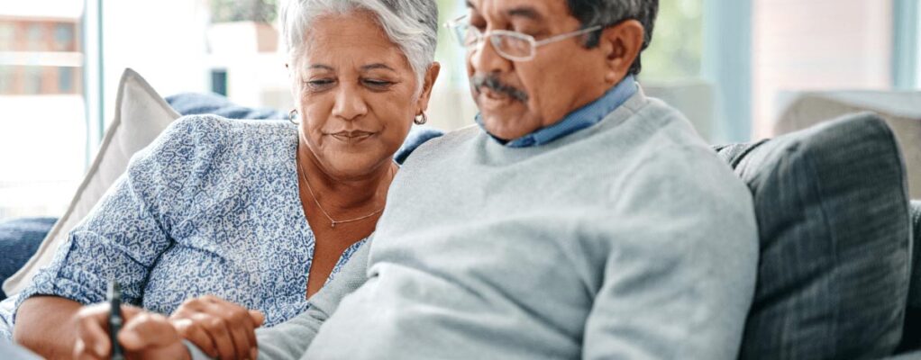 Elderly couple writing down New Year's resolutions.