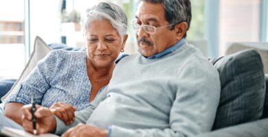 Elderly couple writing down New Year's resolutions.
