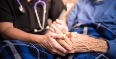 Nursing holding an elderly mans hands
