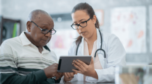 Mesothelioma doctor speaking to an elderly male about their treatment plan