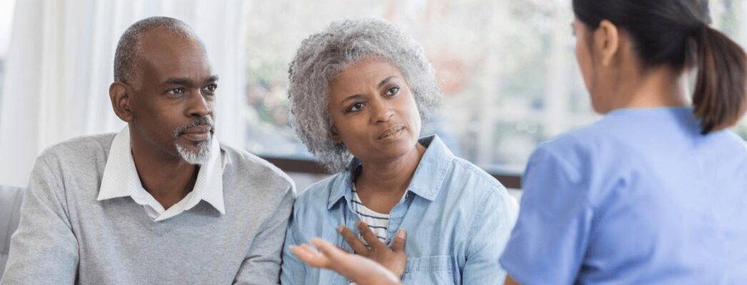 Man and woman speaking with female doctor.