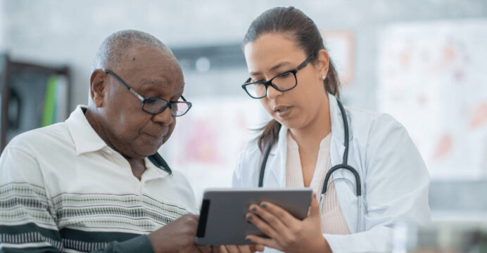 A doctor reviews information with a patient.