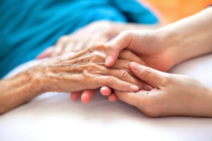 A caregiver holding a patient's hand