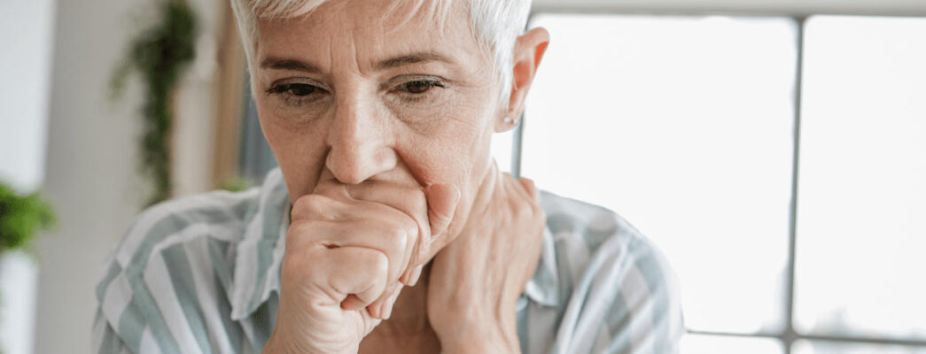 Woman coughs into hand