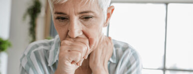 Woman coughs into hand