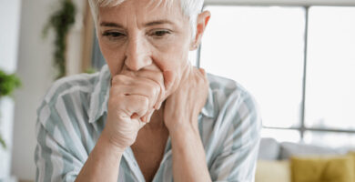 Woman coughs into hand